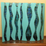Decorative stand-alone wave piece with aqu and colored "stones" of glass. Item number 56: 15" by 13"