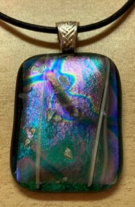 Gorgeous dichroic pendant with colors from all spectrums. Finished with a modern hanger. Item number N75: 1 1/2" x 1 1/4" inches. Price: $25