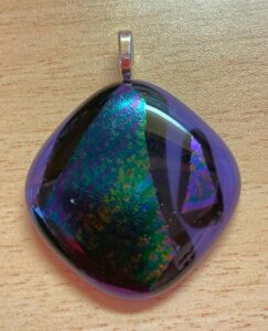Purple opaque glass highlights a purple, green and yellow dichroic glass design. Item number N83: 1 1/4" x 1 1/4" inches. Price: $25