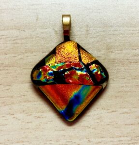 Modern shaped dichroic pendant with in beautiful red, blue, green & gold design. Item number N87: 1 1/4" x 1 1/4" inches. Price: $35