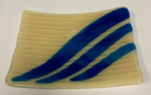 Plate in light yellow on irid white, with ocean blue waves. Item number 214: 8" by 6 1/2". Price: $35