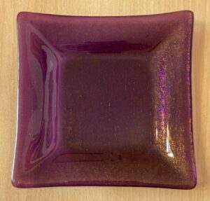 Purple irid plate with gold highlights. With back light, the piece is transparent purple. Item number 231: 7" square. Cost: $45.00